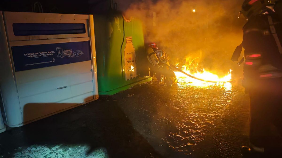 Dos bomberos durante las tareas de extinción del incendio del vehículo,  este domingo, en la carretera de Hoyo de Mazo.