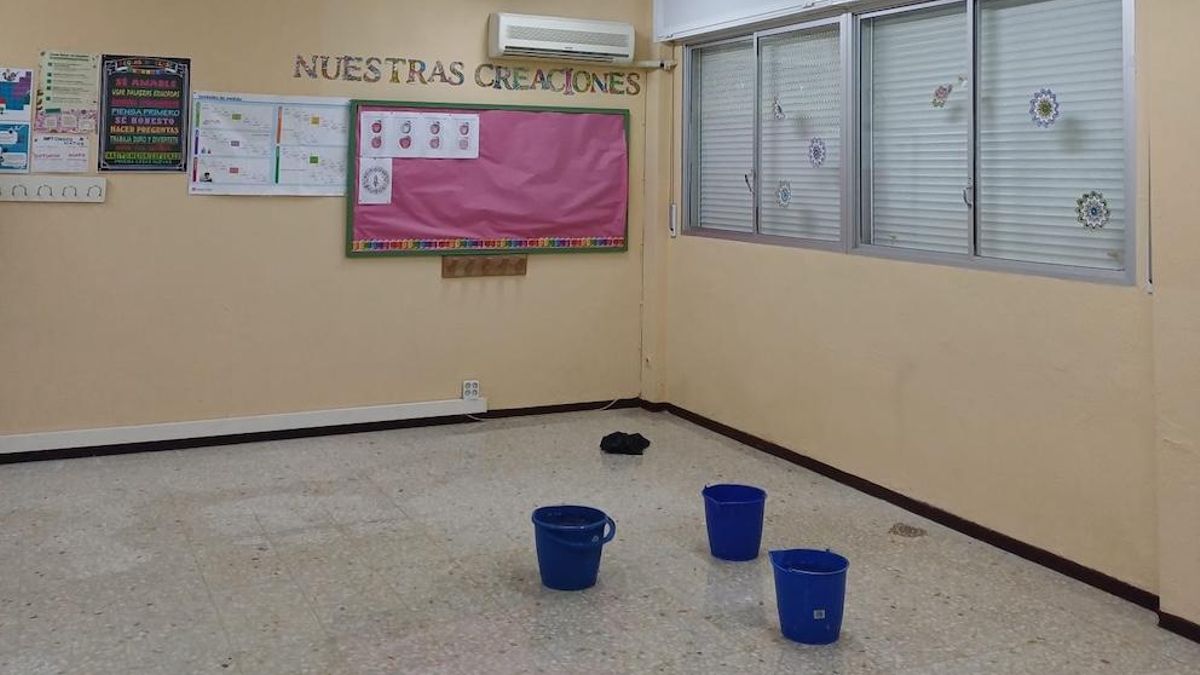 Una de las clases del colegio de Gerena, cerrada y con cubos recogiendo goteras.