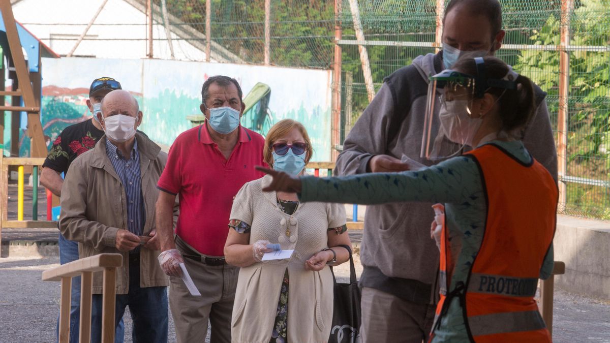 Varias personas protegidas con mascarillas hacen cola para poder votar en las elecciones autonómicas de Galicia