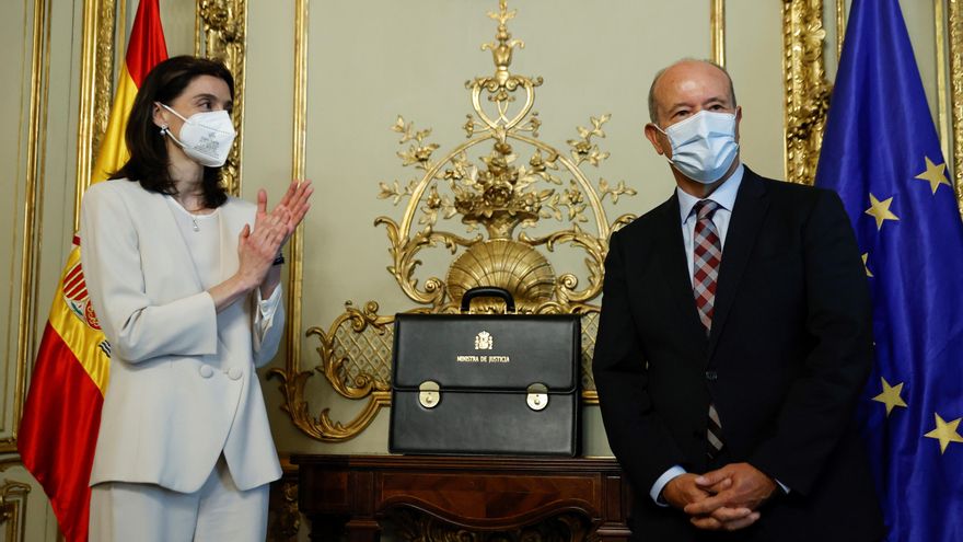 La nueva ministra de Justicia, Pilar Llop, recibe de manos de su antecesor en el cargo, Juan Carlos Campo, durante el acto de traspaso de cartera celebrado este lunes en la sede del ministerio. EFE/Chema Moya