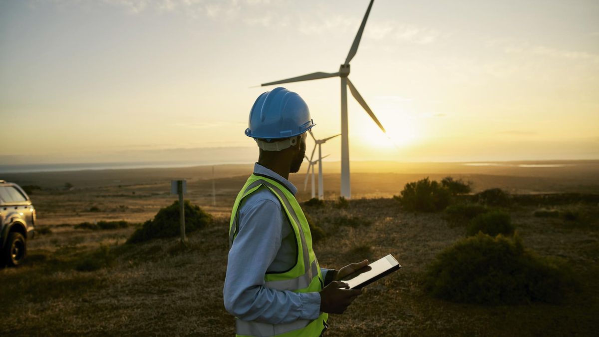 Un ingeniero supervisa una planta de aerogeneradores