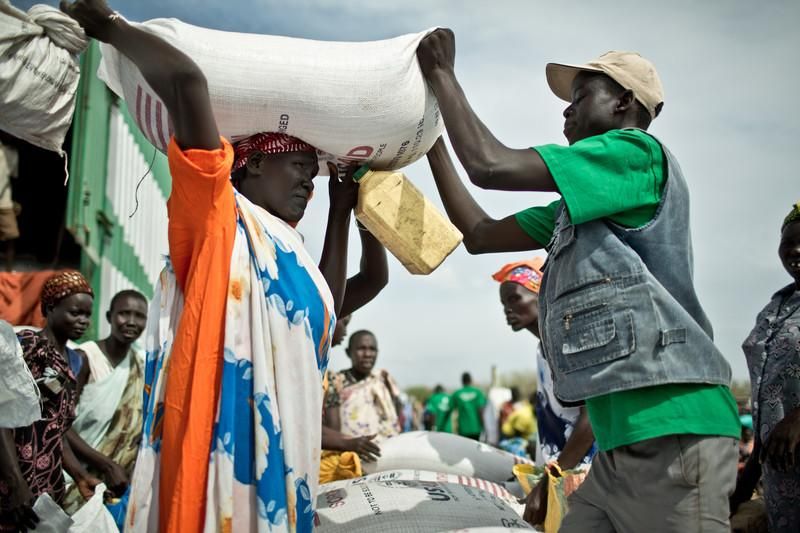 Oxfam Intermón y el Programa Mundial de Alimentos (PMA) está proporcionado ayuda alimentaria a más de 100.000 en Mingkaman. En Mingkaman, cada familia recibe sorgo, lentejas, aceite y sal para alimentarse durante un mes. Martha Nyandit (42 años), madre de 6 hijos. Huyó de los combates en Bor, estuvo 17 días escondida en una isla del río Nilo. Llegó a Mingkaman en enero 2014 donde se enteró que su marido había muerto. No sabe dónde está el resto de su familia y no tiene una tienda dónde refugiarse cuando llueve. Llegó sin nada y depende de que las otras mujeres le presten sus cazos para poder cocinar.  El campo de desplazados de Mingkaman, en Awerial, se ha convertido en refugio para casi 100.000 personas, principalmente de la etnia dinka, que huyeron de los enfrentamientos violentos en el estado de Jonglei, principalmente de la ciudad de Bor. Las personas que llegan necesitan agua, comida y un techo dónde refugiarse.  Sudán del Sur afronta una grave crisis a causa de la violencia que se desató en diciembre de 2013 entre las fuerzas leales al presidente Salva Kiir, y los combatientes aliados al ex vicepresidente Riek Machar. Cerca de un millón de personas han tenido que abandonar sus hogares a causa de los enfrentamientos y se han quedado sin medios propios para alimentarse. Un tercio de la población sufre inseguridad alimentaria./ Pablo Tosco/Oxfam Intermón