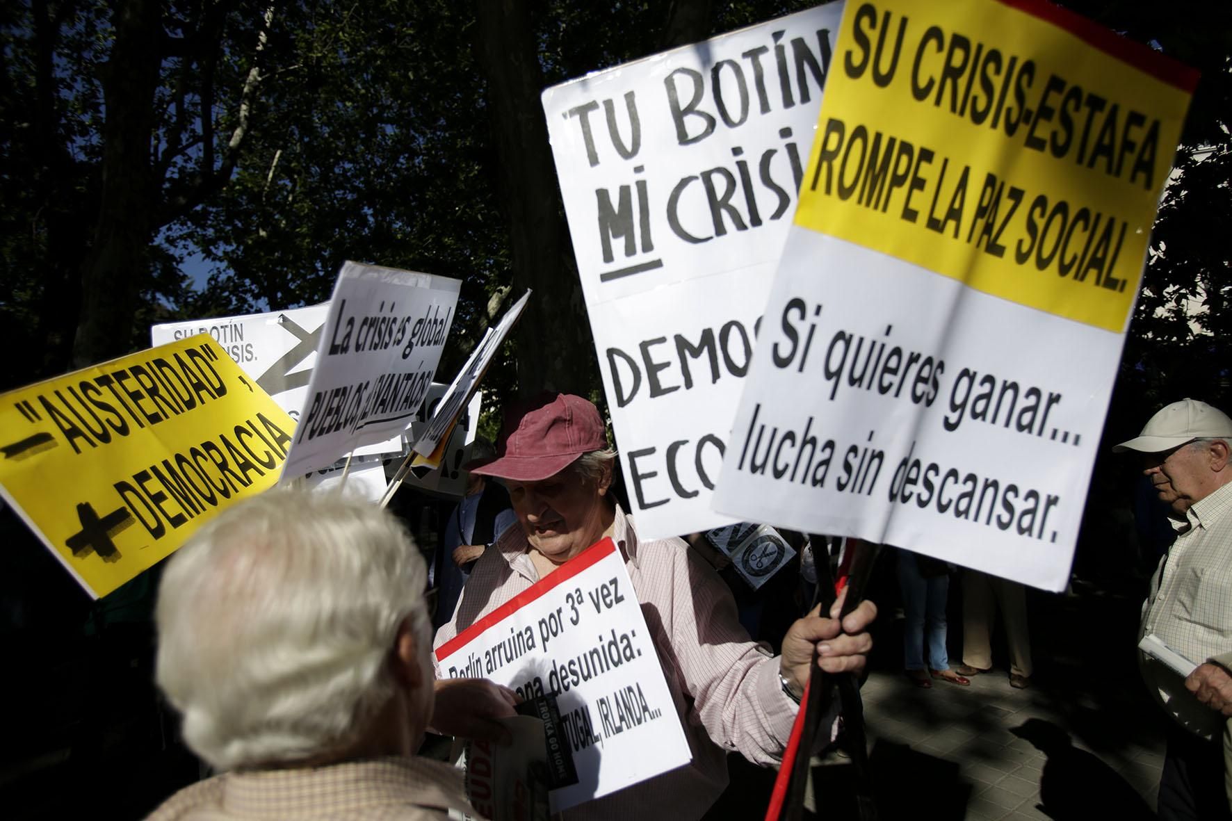 Reparto de carteles contra la troika durante la manifestación