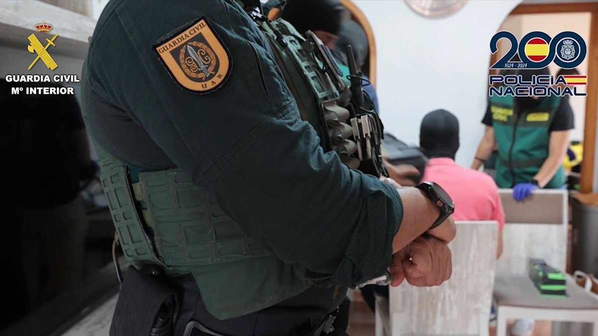 Agente de la Guardia Civil en el registro de un domicilio por el robo en 13 sucursales bancarias.