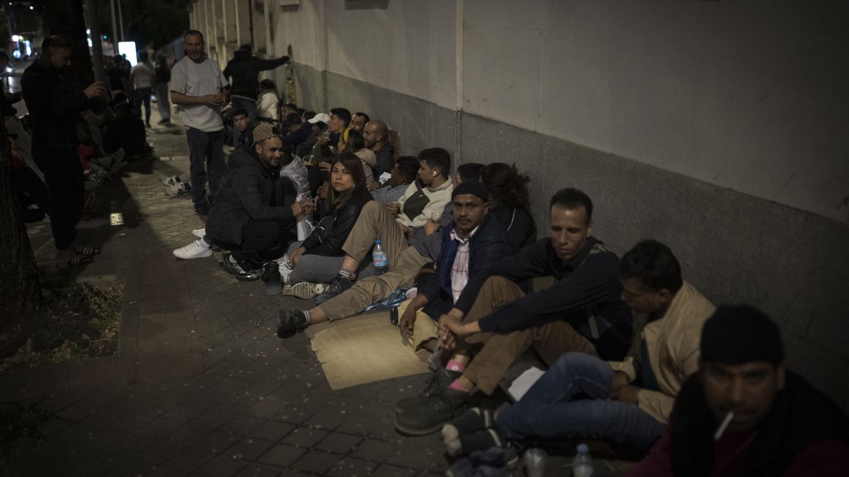 Fila de personas migrantes que hacen noche para conseguir el certificado de vulnerabilidad en los servicios sociales de Madrid.