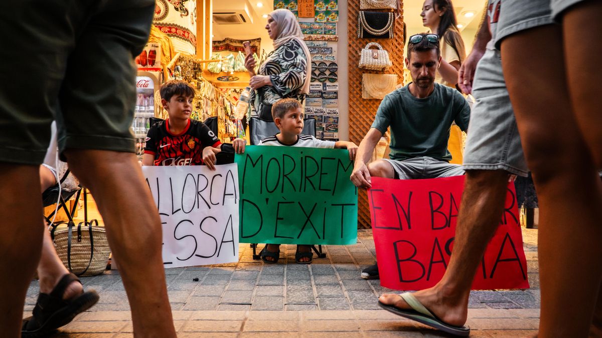 Uns joves i un adult en la protesta d'aquest dissabte. "Morirem d'èxit", pot llegir-se en un dels cartells.