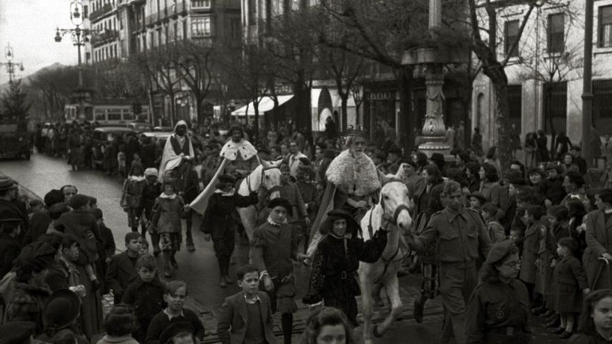 Cabalgata de Reyes recorriendo la Avenida de la Libertad de Donostia. Grupo folclórico precedido por txistularis, falangistas y soldados en 1943