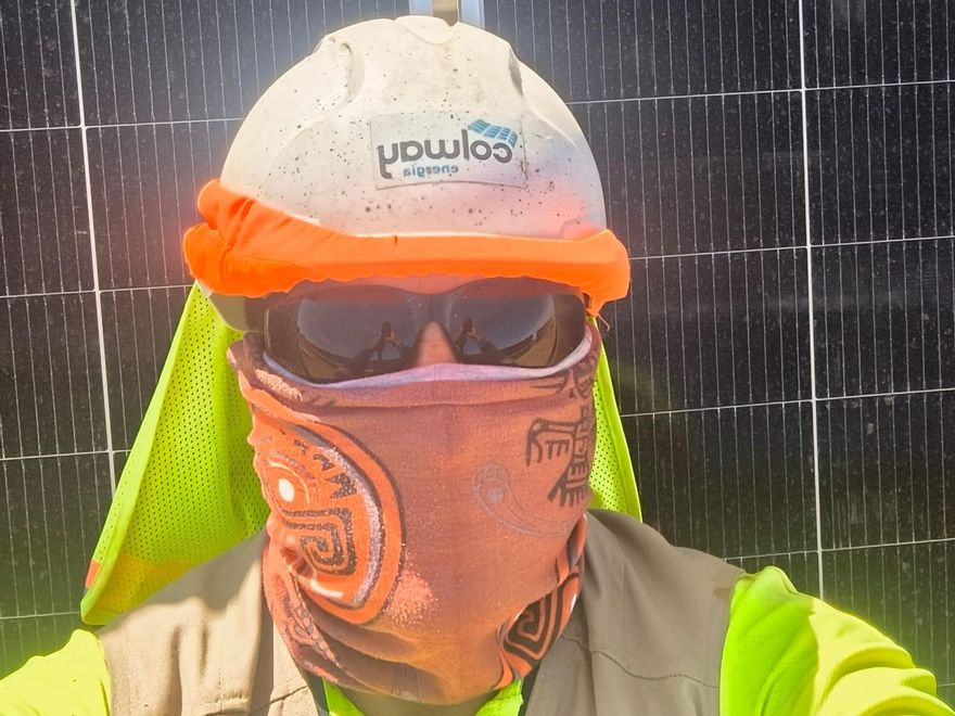 Uno de los componentes de la cuadrilla procedente de Chile con uniforme de Colway Industrial durante su trabajo como instalador de placas fotovoltaicas en España.