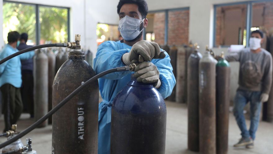 Varios trabajadores llenan cilindros de oxígeno en una instalación de suministro de gas en Srinagar, la capital de verano de la Cachemira india. EFE/EPA/FAROOQ KHAN