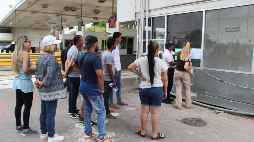 Migrantes buscan sus nombres en las listas que colocaron las autoridades mexicanas en la línea fronteriza de Paso del Norte, en la ciudad de Matamoros, en el estado de Tamaulipas (México).
