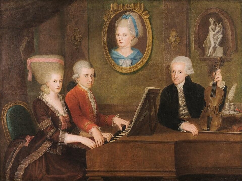 Wolfgang Amadeus Mozart con su hermana Maria Anna y su padre Leopold; en la pared, un retrato de la madre fallecida, Anna Maria.