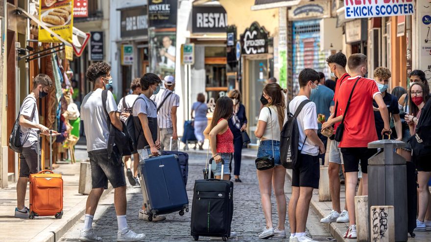 Un grupo de turistas esperan junto a sus maletas en el centro histórico de Valencia. EFE/Biel Aliño/Archivo