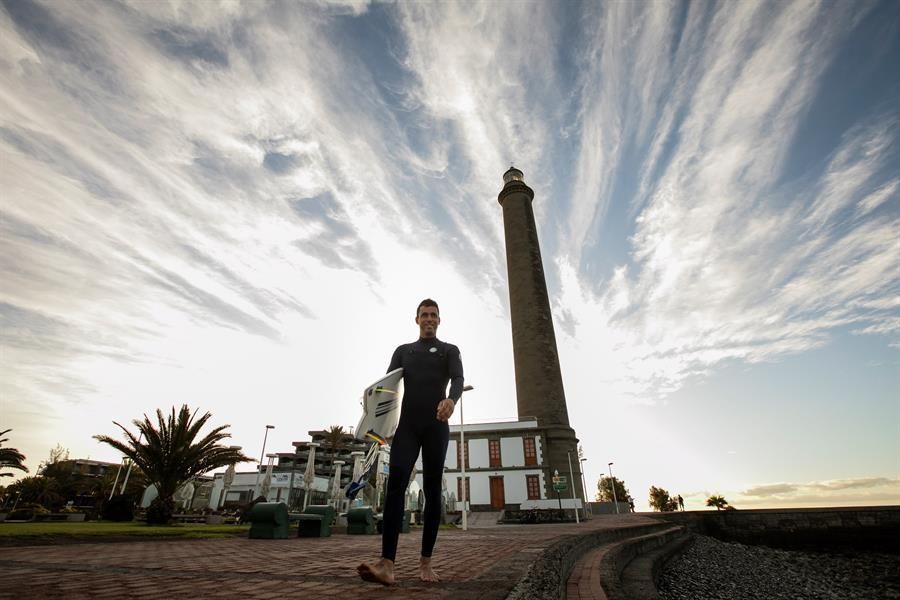 Un surfero en frente al Faro de Maspalomas preparado para coger las primeras olas tras el confinamiento