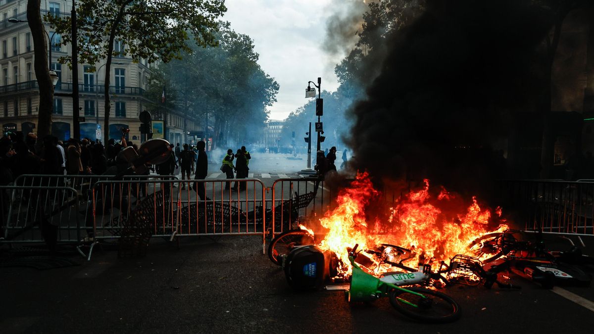 Una barricada arde mientras manifestantes se enfrentan a la policía durante una protesta contra el aumento del costo de vida y los recortes en los servicios públicos en París.