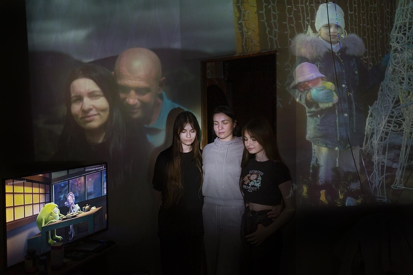 Irene con sus dos hijas, de fondo una fotografía con el padre de ellas y una foto de cuando eran pequeñas. Al lado, una televisión con la película Monster Inc.