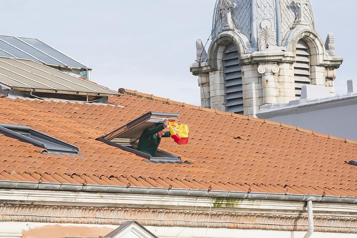 Un ciudadano muestra su bandera desde una ático en Santander como apoyo a los manifestantes.