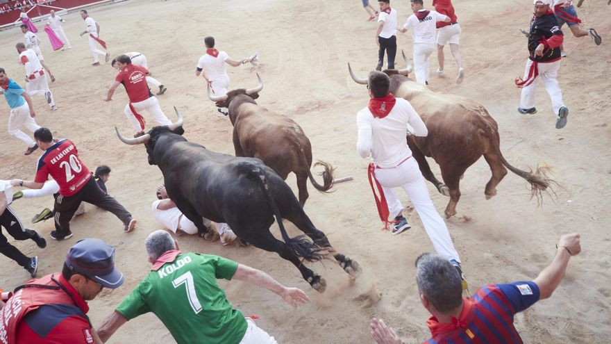 Multitud de personas corren durante el último encierro de las Fiestas de San Fermín 2022 con toros de Miura, a 14 de julio de 2022, en Pamplona, Navarra (España). Las fiestas en honor a San Fermín, patrón de Navarra, acaban hoy con el cántico del ‘Pobre d