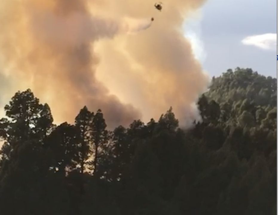 En la imagen, el  helicóptero de la BRIF realizando una descarga de agua sobre el incendio forestal en la zona de Catela, en Garafía.