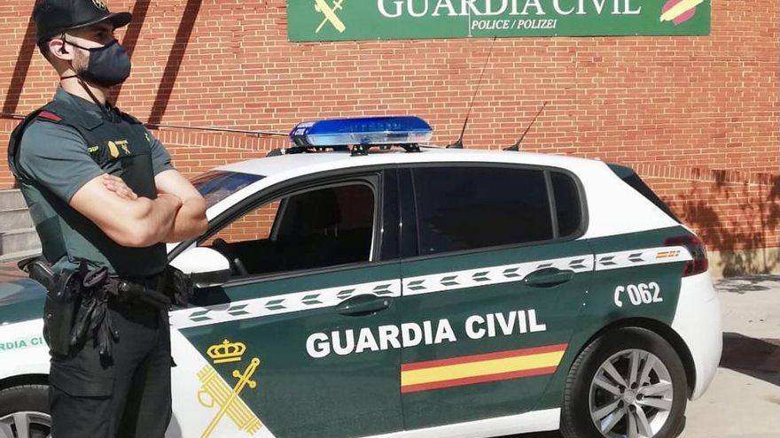 Archivo - Un agente de la Guardia Civil, junto a un vehículo del cuerpo.