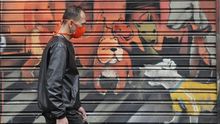 Un hombre camina con tapabocas por las calles este viernes durante la cuarentena por el coronavirus, este viernes en Bogotá (Colombia).