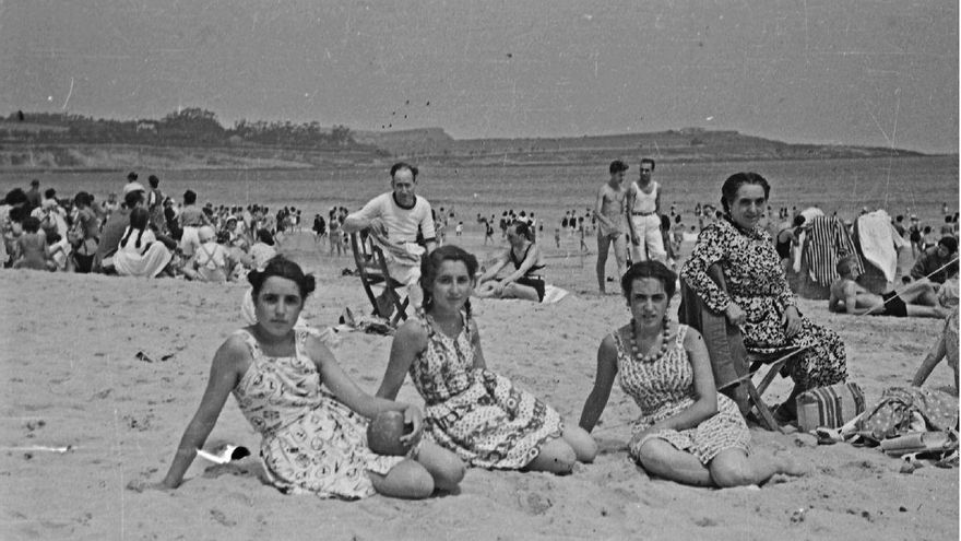 1947. Una familia posa en la arena de la playa con el litoral de la costa como fondo.
ARCM