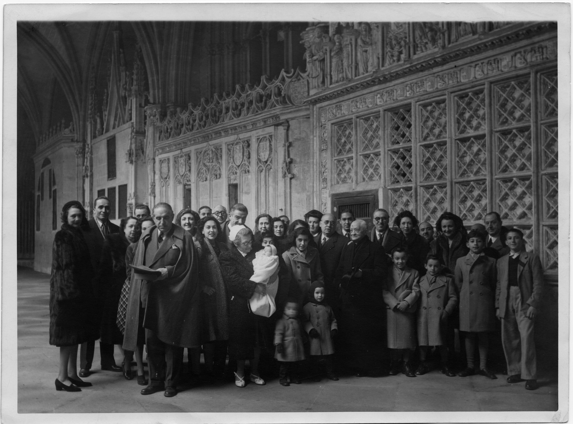 Asistentes a un bautizo, entre ellos Gregorio Marañón, posan en el claustro bajo de la Catedral de Toledo. Años 50.