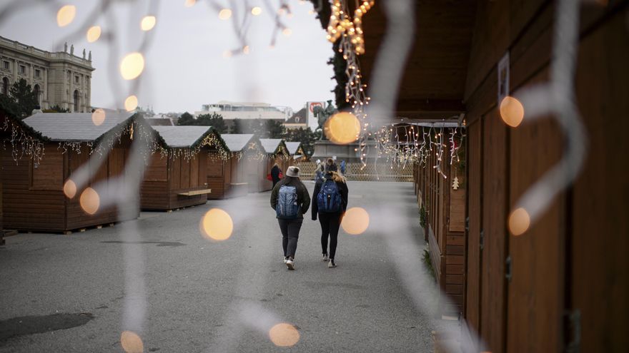 Dos personas caminan por un mercado navideño cerrado en el primer día de confinamiento en Viena.