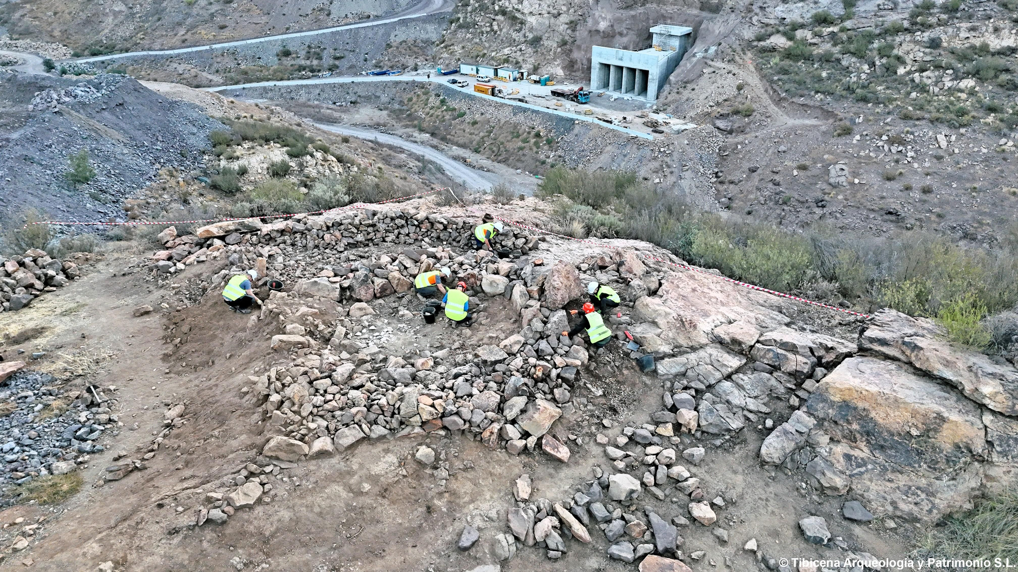 El muro en la parte superior del yacimiento son las piedras que los arqueólogos han sacado del interior de la estructura indígena.