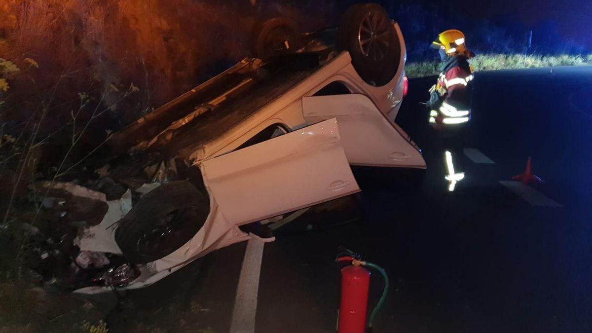 En la  imagen, un bombero junto al vehículo accidentado.