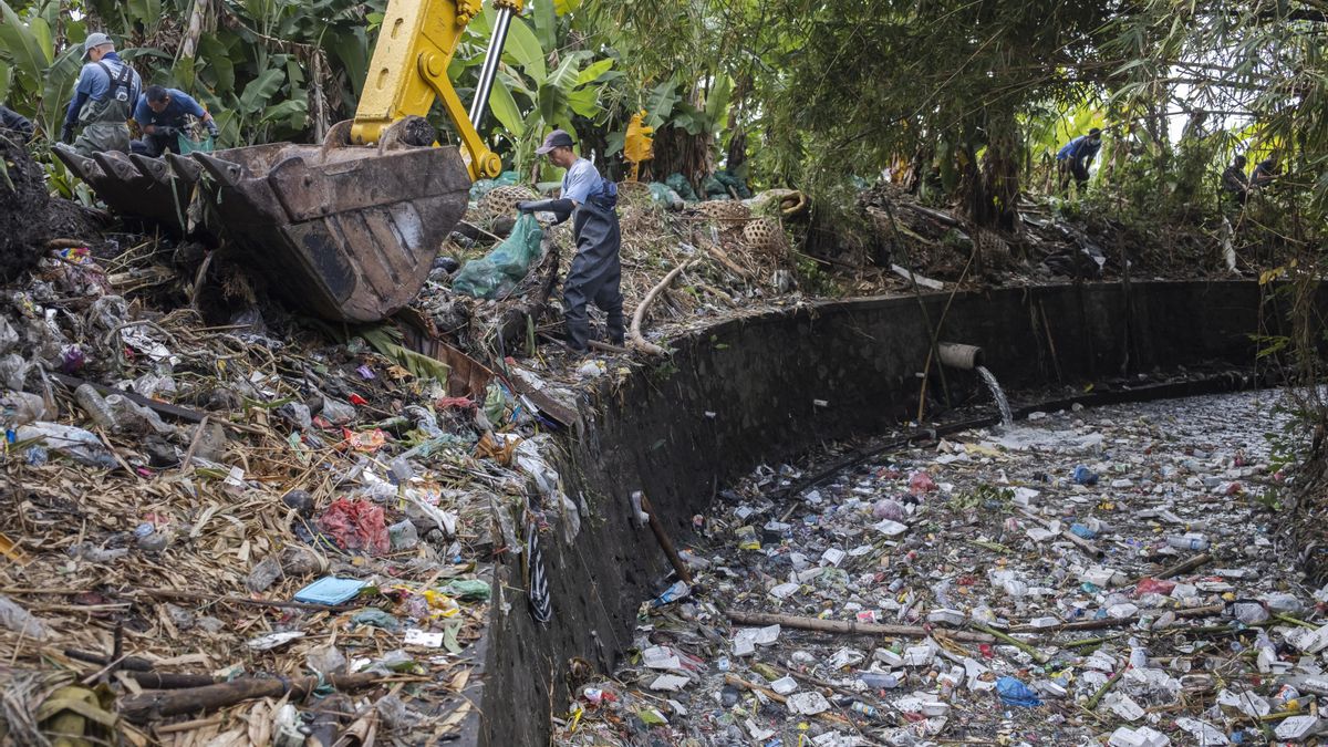 Un voluntario limpia de basura plástica un río en Indonesia.