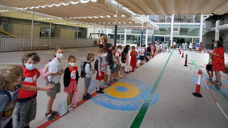 Els xiquets esperen en fila l'entrada a classe en el Ceip Balmes de València en el primer dia de col·le.