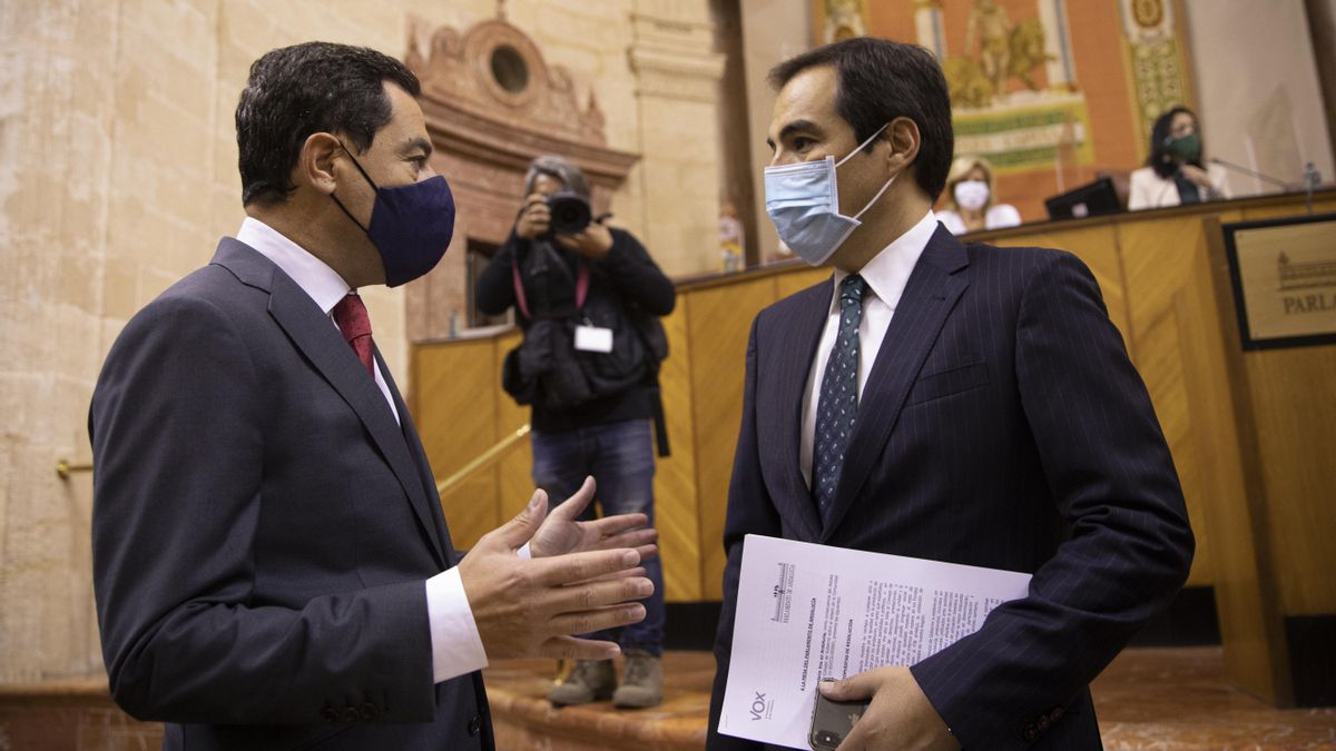 El presidente de la Junta de Andalucía, Juanma Moreno (i), junto al portavoz del grupo parlamentario popular, José Antonio Nieto, al inicio de la segunda jornada del Debate sobre el Estado de la Comunidad en el Parlamento de Andalucía