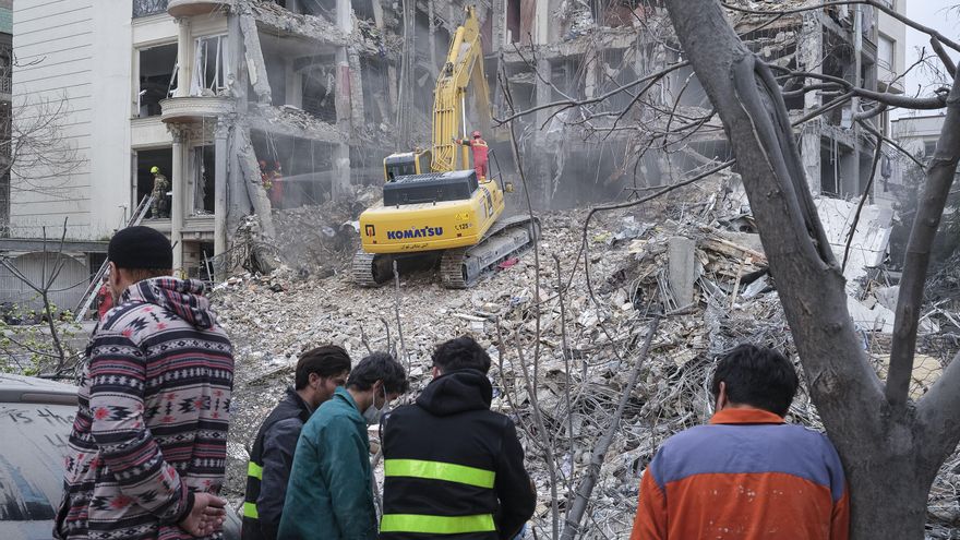 Un grupo de rescatistas trabaja entre los escombros de un edificio que fue atacado por Estados Unidos e Israel esta mañana en el barrio de Andarzgu, en el noreste de Teherán.