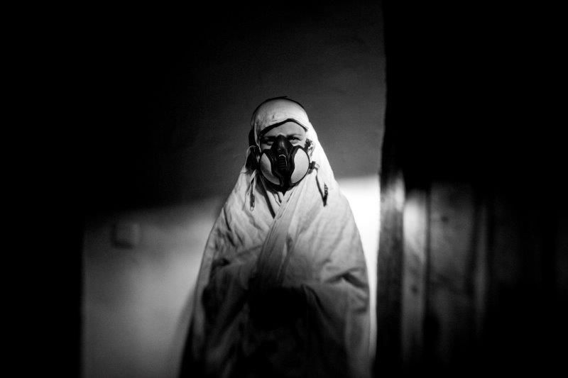 Una mujer utiliza una máscara con un filtro de carbón activado para evitar la inhalación de productos químicos.