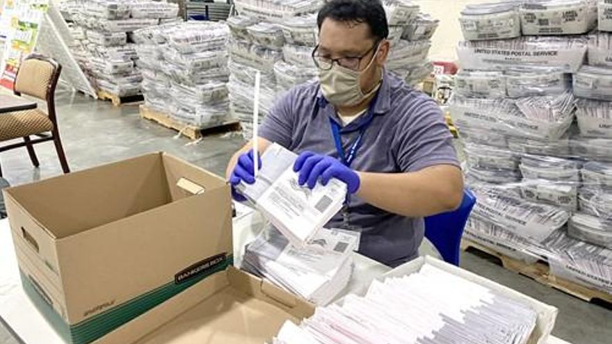 Un empleado trabaja en el proceso de verificación del voto por correo en California