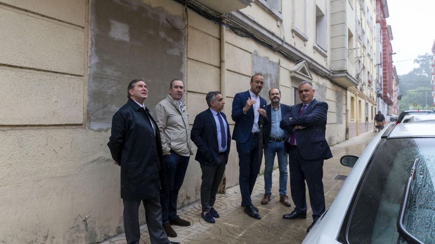 El consejero de Fomento, Roberto  Media, y el alcalde de Torrelavega, Javier López Estrada, junto al edificio de La Inmobiliaria donde se van a construir 12 viviendas de alquiler asequible