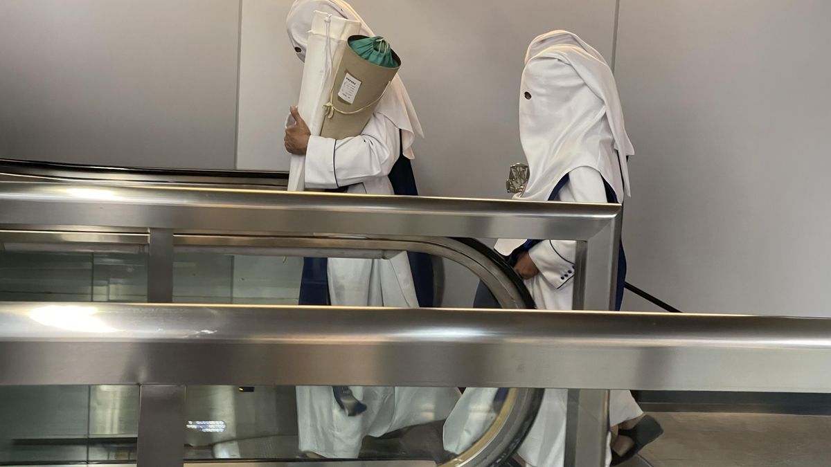 Nazarenos de los Negritos en el Metro camino de su estación de penitencia