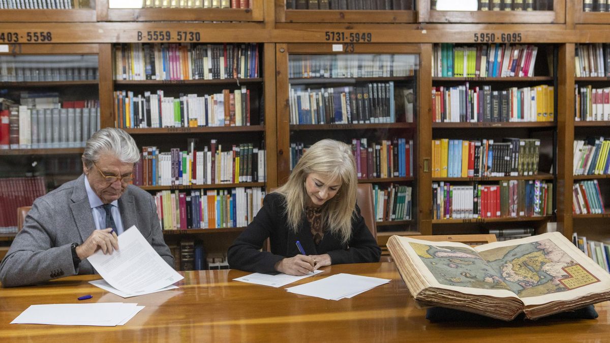 El presidente de la Fundación Villacisneros y la consejera de Desarrollo Educativo firmando el convenio en la biblioteca del instituto San Isidoro