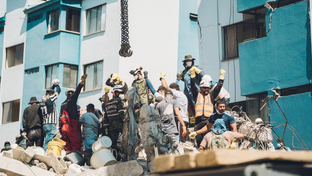 Los equipos de rescate con el puño levantado y en silencio tratan de escuchar si hay alguien debajo de los escombros, en la ciudad de Pereira, el 11 de agosto de 2026.