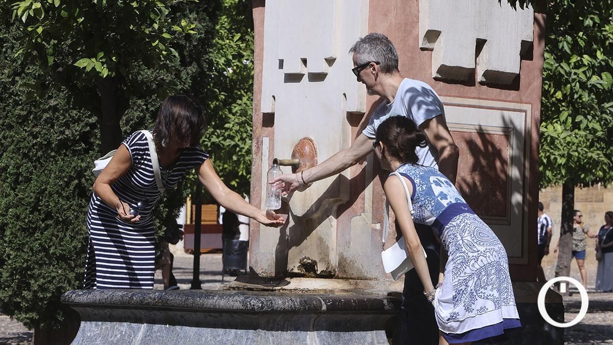 Turistas refrescándose en la fuente del Patio de los Naranjos por las altas temperaturas