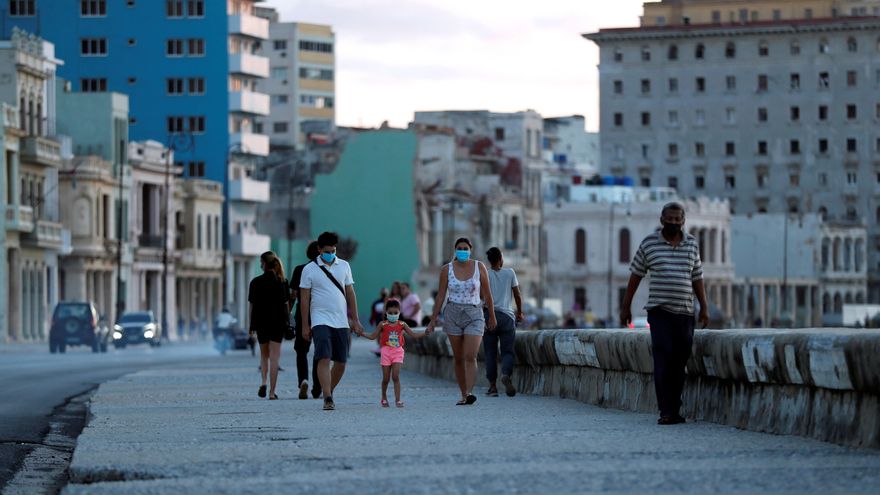 Personas caminan por el malecón en la Habana (Cuba).
