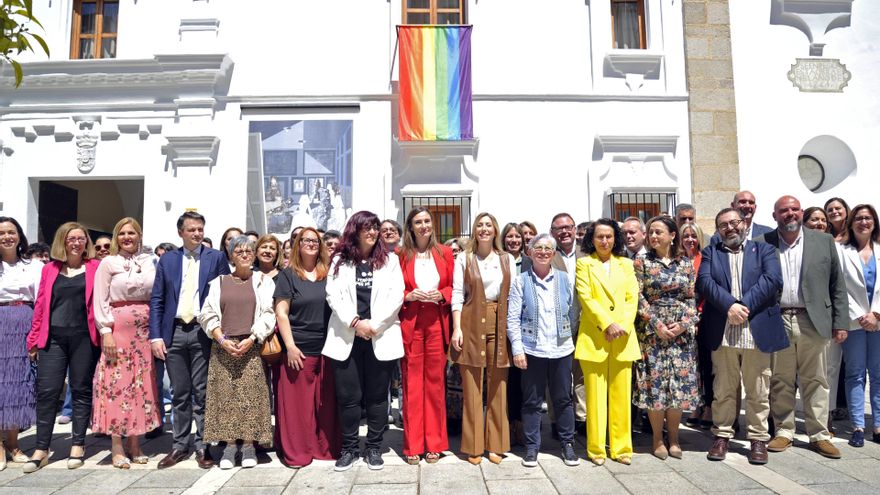 Foto de familia con la bandera arcoiris tras el acto institucional en la Asamblea por el Día contra la LGTBIFobia.