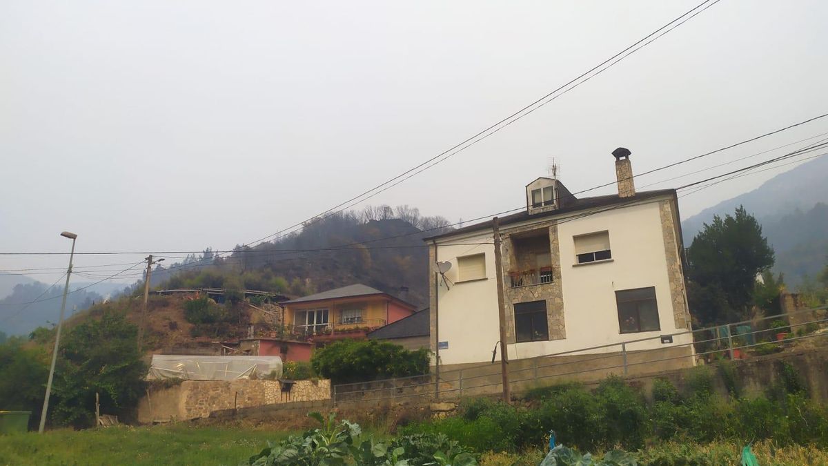 Las casas del barrio de abajo de Oulego, con el campo quemado a su espalda.