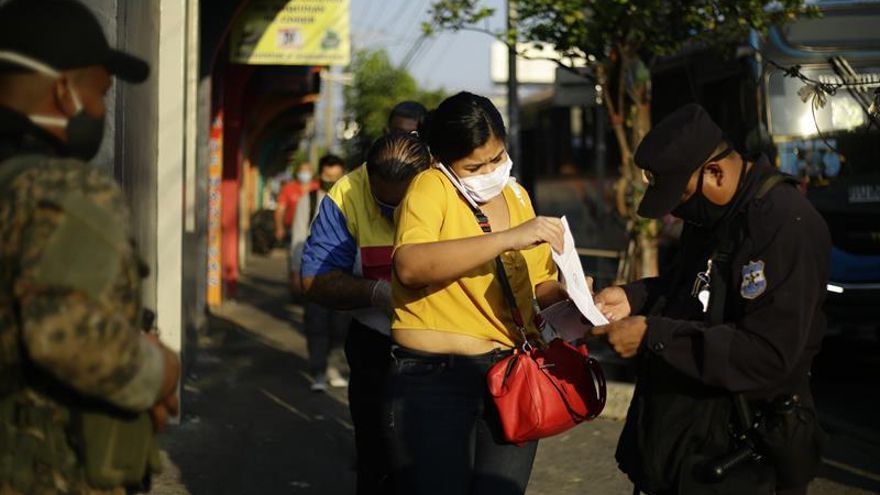 Agentes policiales mantienen un punto de control para personas que deban desplazarse por el centro de San Salvador (El Salvador).