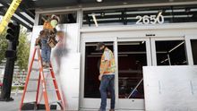 Workers clean up glass and board up businesses after overnight protests over the Minnesota arrest of George Floyd, who later died in police custody, in Oakland, California, USA.