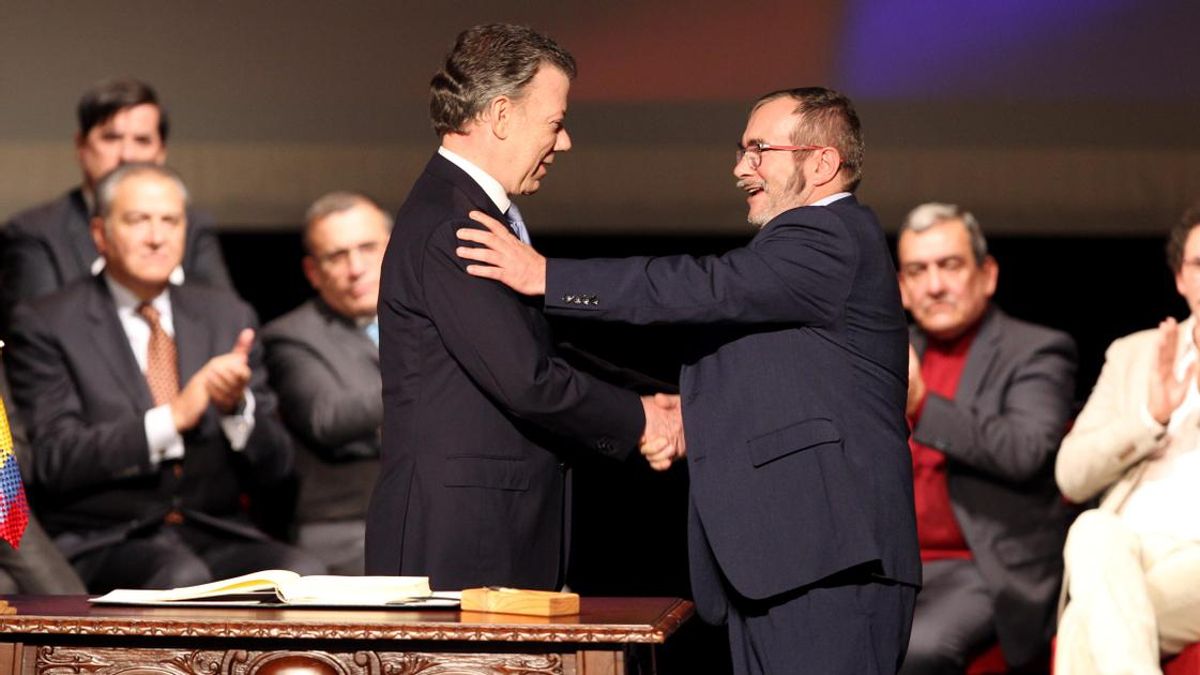 El presidente de Colombia Juan Manuel Santos (i), y el jefe máximo de las FARC, Rodrigo Londoño Echeverry, alias Timochenko (d), se felicitan luego de firmar el nuevo acuerdo de paz el 24 de noviembre de 2016 en Bogotá.