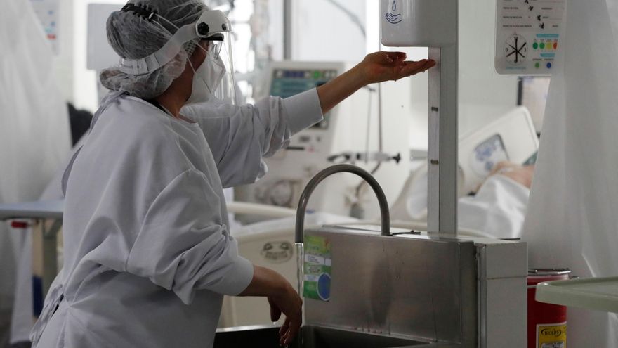 Una empleada de la salud desinfecta sus manos en una unidad de cuidados intensivos para enfermos de covid-19 en el Hospital El Tunal en Bogotá, en una fotografía de archivo. EFE/Carlos Ortega