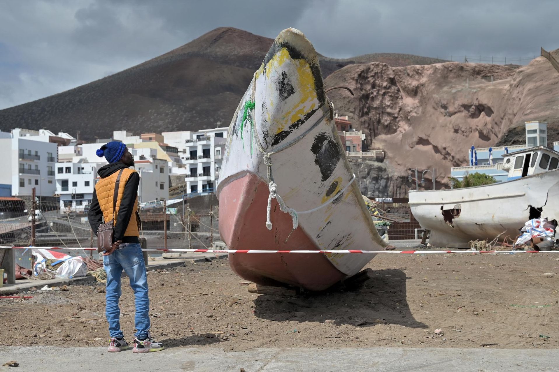 Oumar Diallo observa en el muelle de La Restinga (El Hierro) un cayuco similar al que transportaba a su hermano Ibrahim y a dos primos, que murieron en el naufragio ocurrido en la costa de la isla el 28 de septiembre.