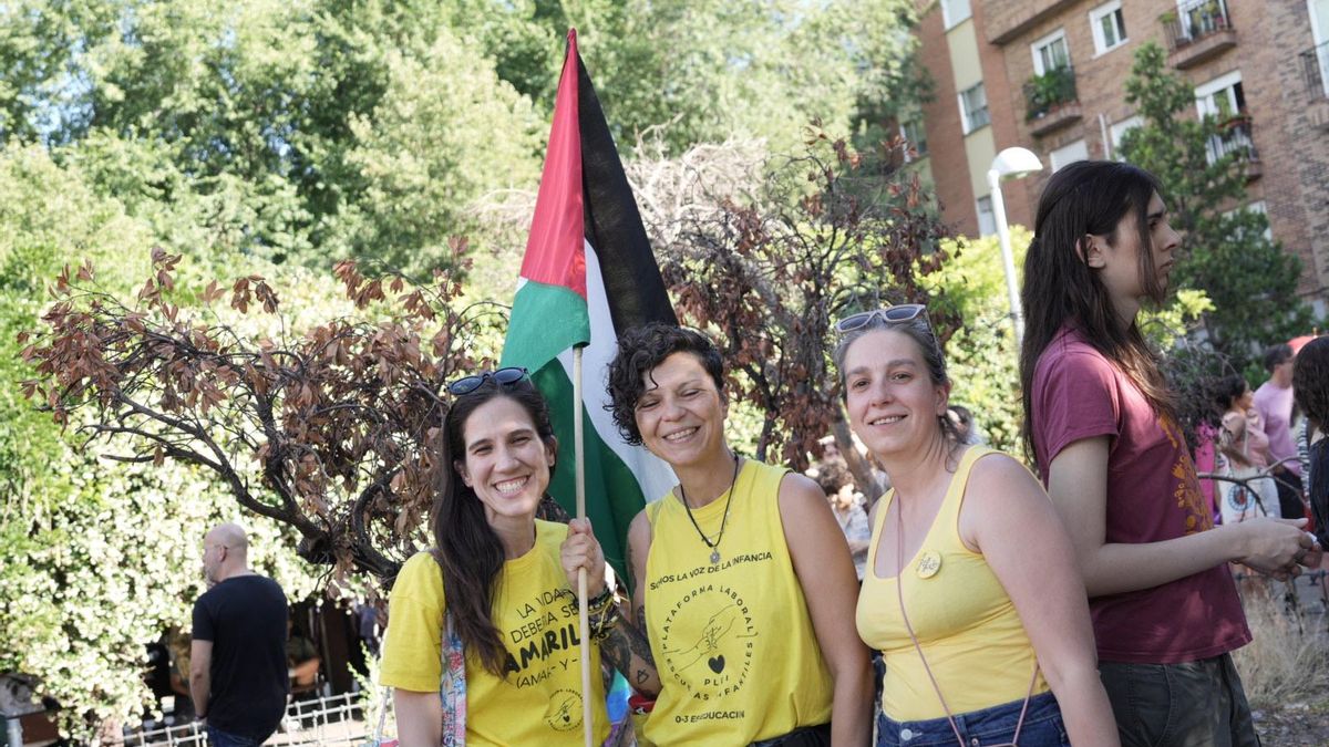 Tres jóvenes en la manifestación, una de ellas portando una bandera de Palestina.