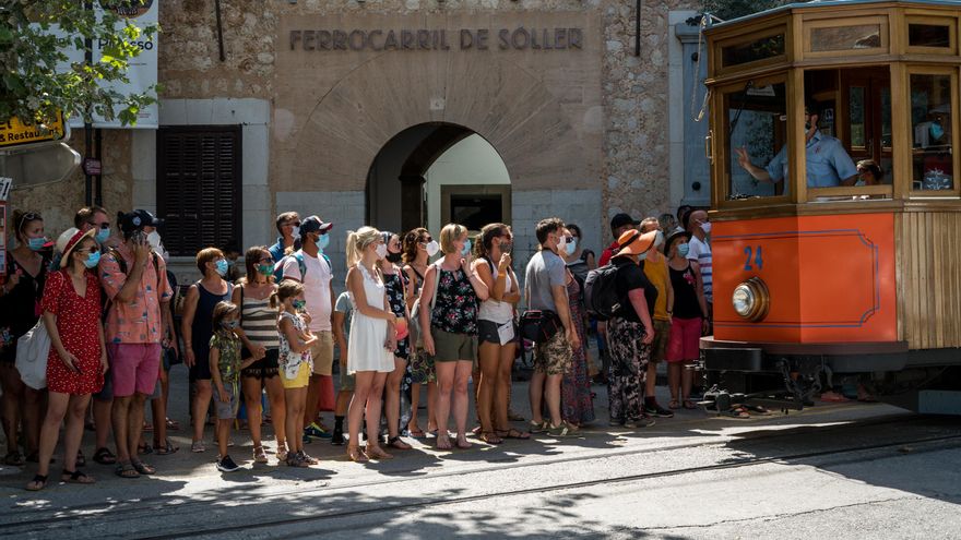 Un grupo de turistas, espera el tranvía que se dirige a Sóller, Mallorca, Islas Baleares (España), a 28 de julio de 2020. La foto está tomada un día después de que Gobierno del Reino Unido desaconsejase todo viaje no esencial a España, incluidas Baleares y Canarias, a causa de los ‘riesgos’ que supone la situación de la pandemia de coronavirus en España.